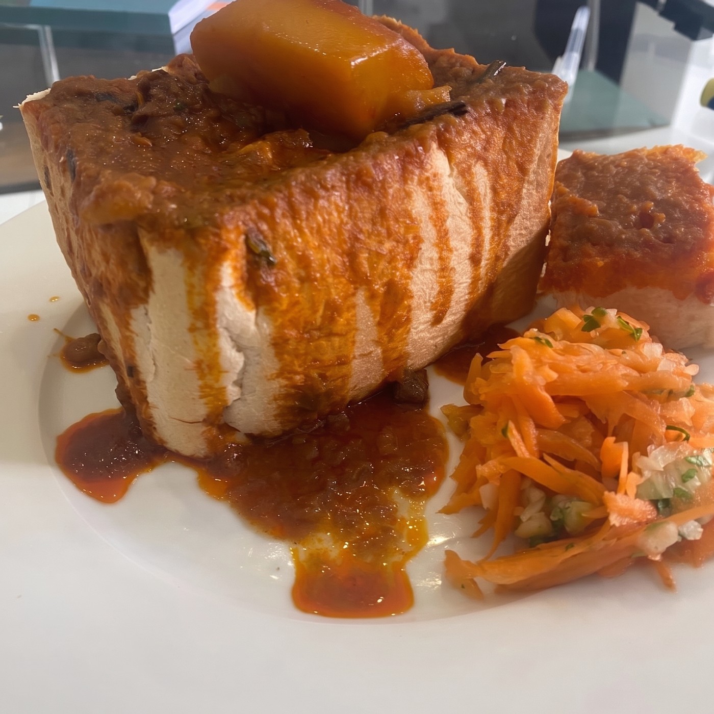 Durban bunny chow topped with potato, served with carrot salad